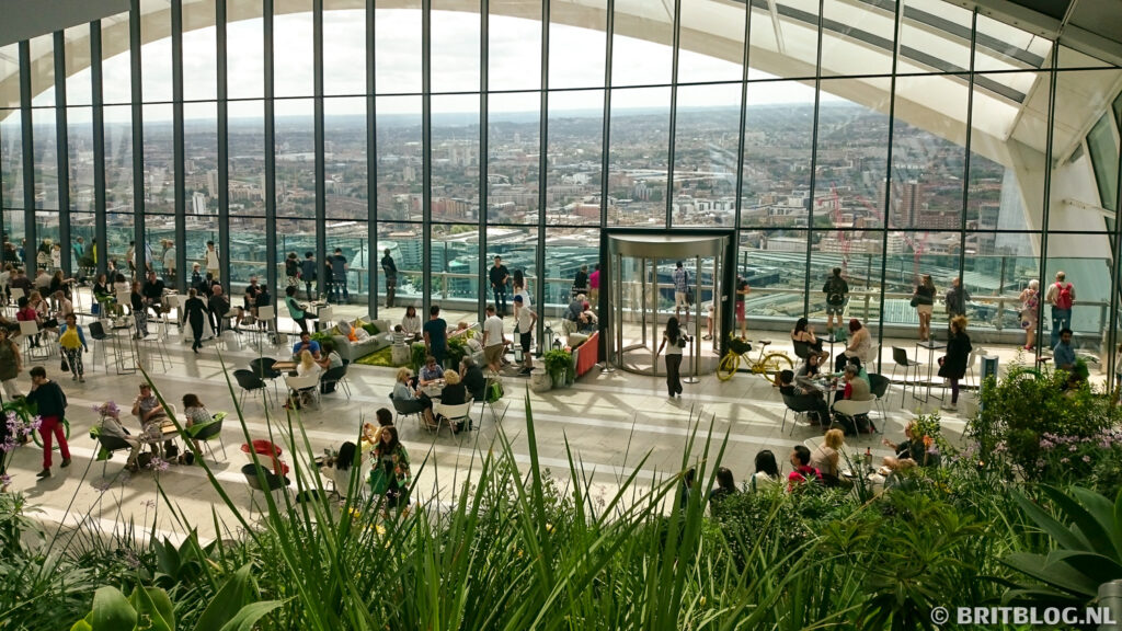 Bezoekers in de Sky Garden in Londen genieten van het panoramisch uitzicht over de stad, omringd door tropische planten en moderne architectuur.