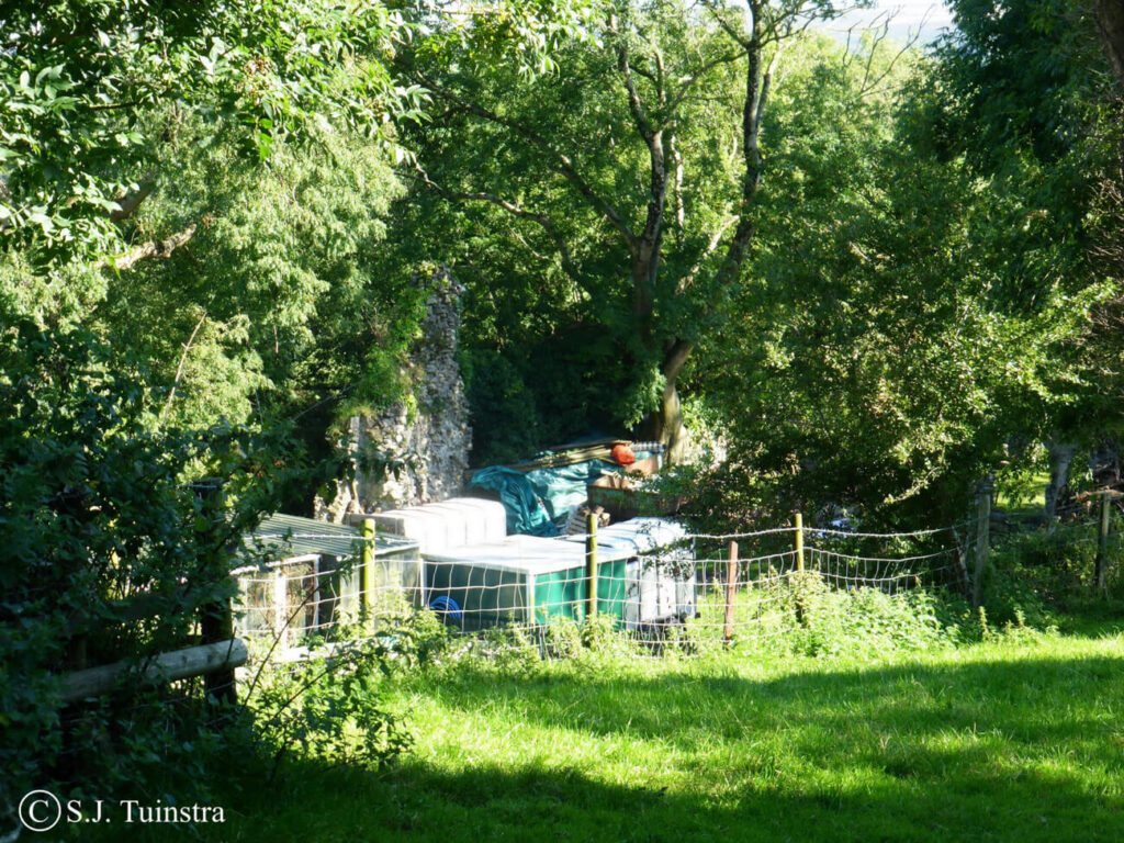 In een achtertuin, tussen de bomen, de schamele restanten van Bovehill Castle