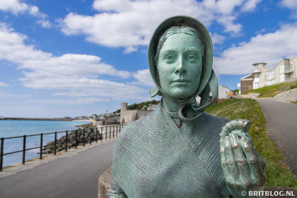 Standbeeld van Mary Anning met een fossiel in Lyme Regis langs de Jurassic Coast, Dorset. 
