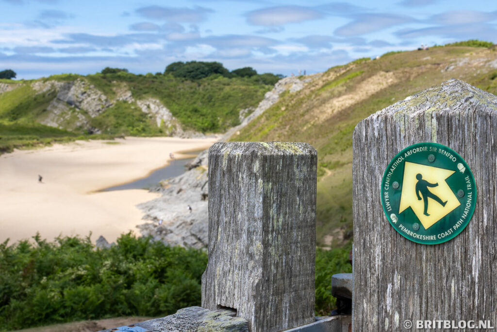 Pembrokeshire Coast Path bordje met op de achtergrond het strand