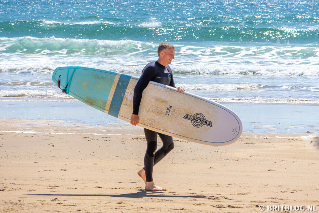 Man met surfplank op het strand van Freshwater West