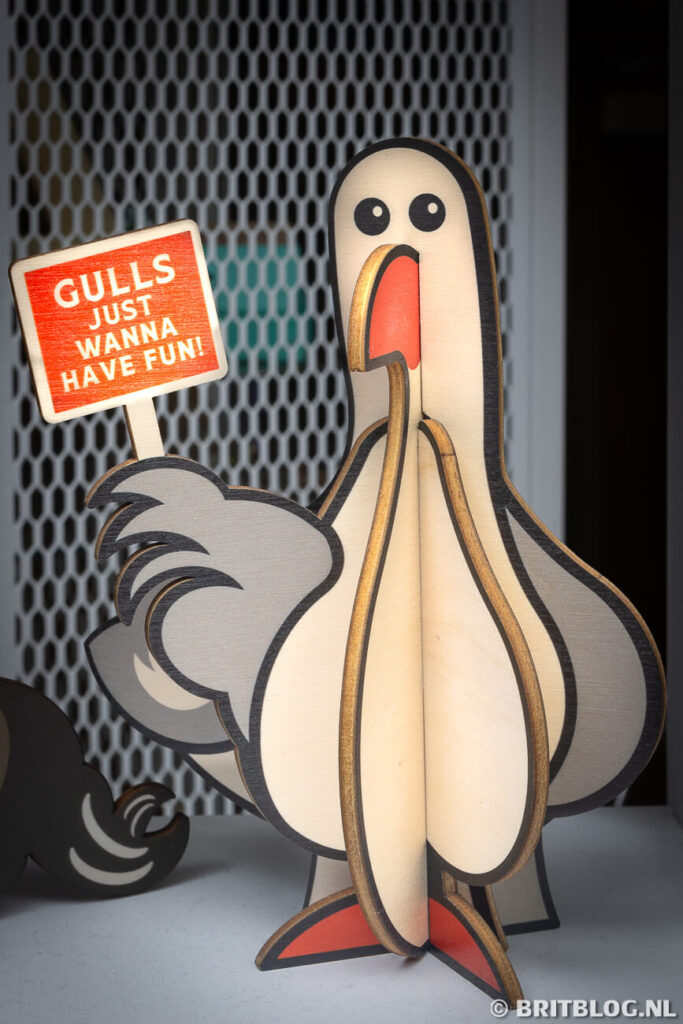 Een houten meeuw met het bordje 'Gulls just wanna have fun!' Welshe souvenirs, Tenby
