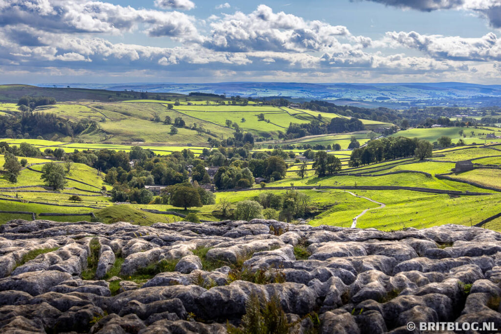 Het uitzicht vanaf Malham Cove over het glooiende landschap van de Yorkshire Dales.