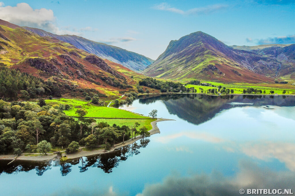 Buttermere vanuit de lucht met blauwe lucht en reflecties.