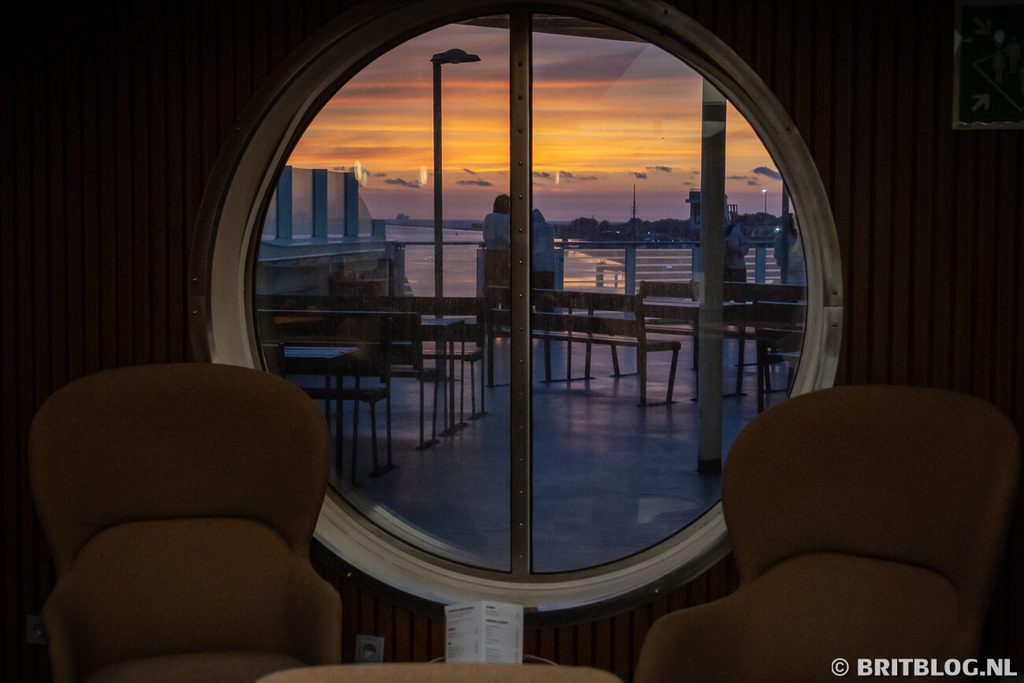 Stoelen op een Stena Line boot met buiten een zonsondergang